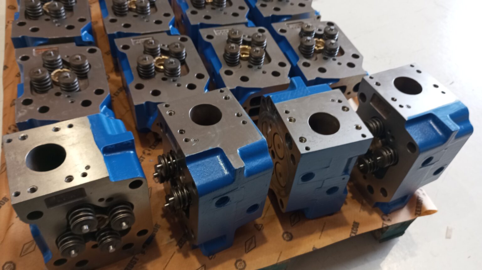Batch of reconditioned MWM TCG 2016 cylinder heads packed with anti-corrosion paper, ready for delivery